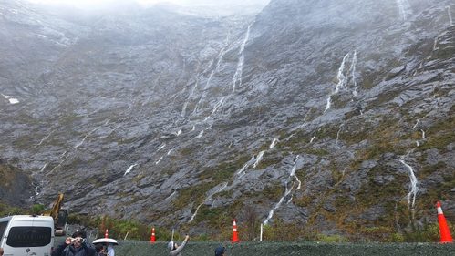 雨の日のクレダウ渓谷の周りの岩壁には無数の長い滝がかかる