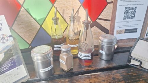 Erik's Fish & Chips の店頭で無料提供されているモルトビネガー、チキンソルト、塩、胡椒の容器