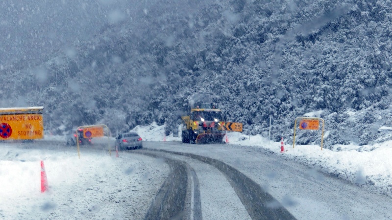 積雪のため除雪車が作業しているホーマートンネル前後の道路