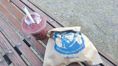 ワカティプ湖畔のベンチで食べるファーグバーガー