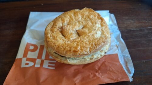 The Butcher's PIEをリバーサイドマーケット内のテーブル椅子で食べる